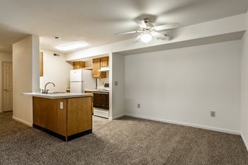 A kitchen with a sink, refrigerator, and a ceiling fan at Pheasant Run Apartments, Lafayette, Indiana